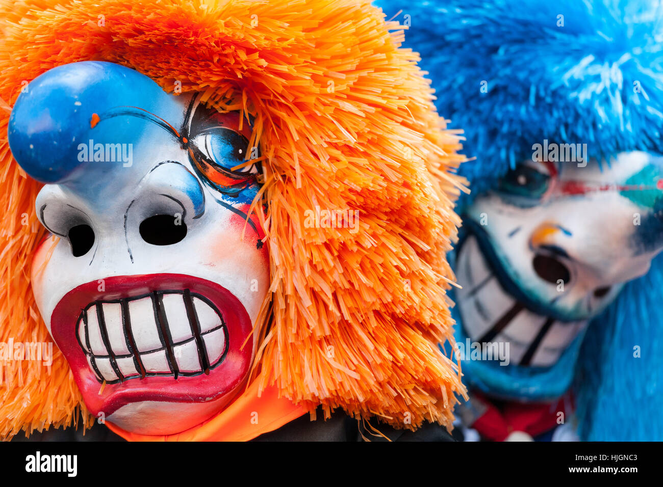 Two Traditional Waggis Masks With Orange And Blue Hair At Fasnacht
