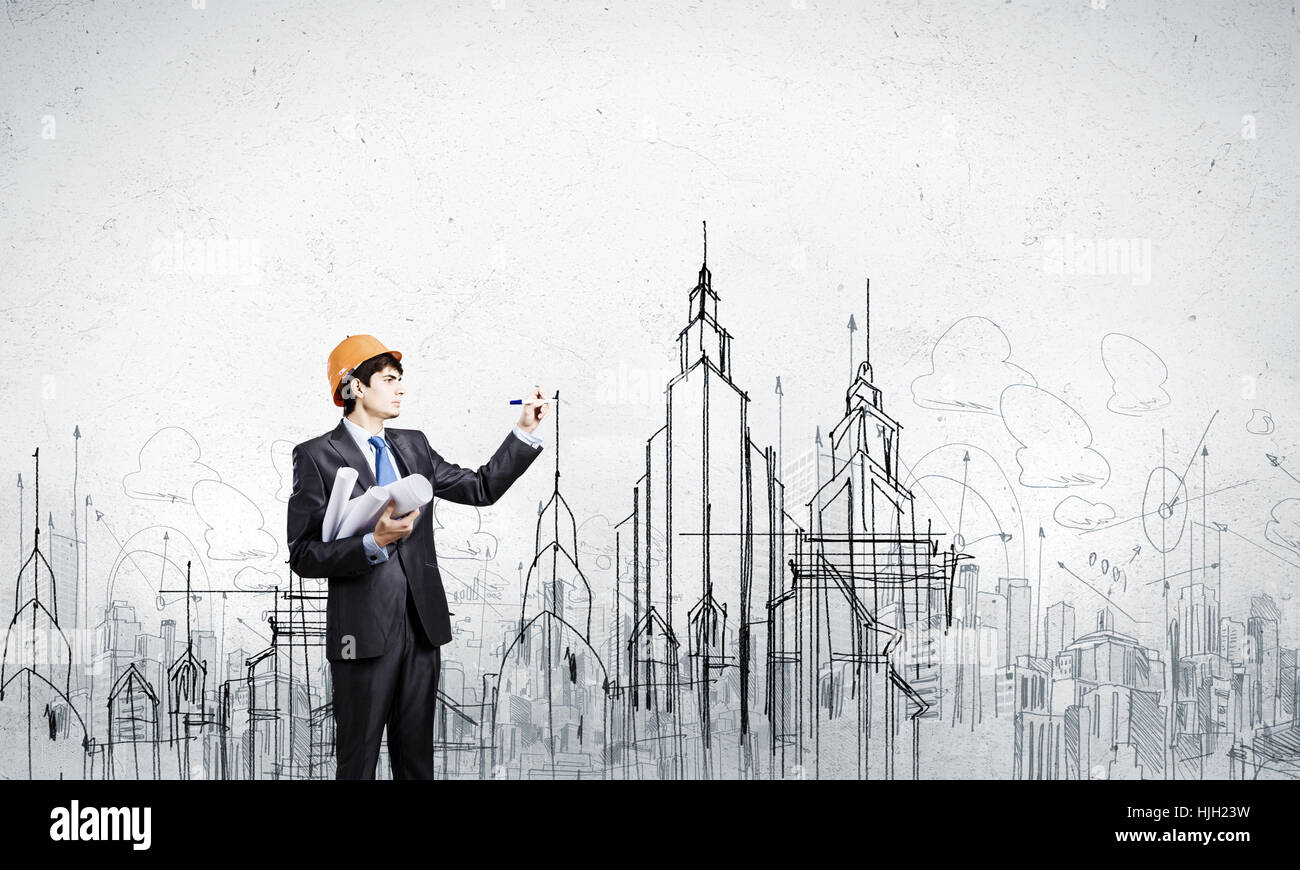 Young man engineer in helmet drawing construction project Stock Photo ...