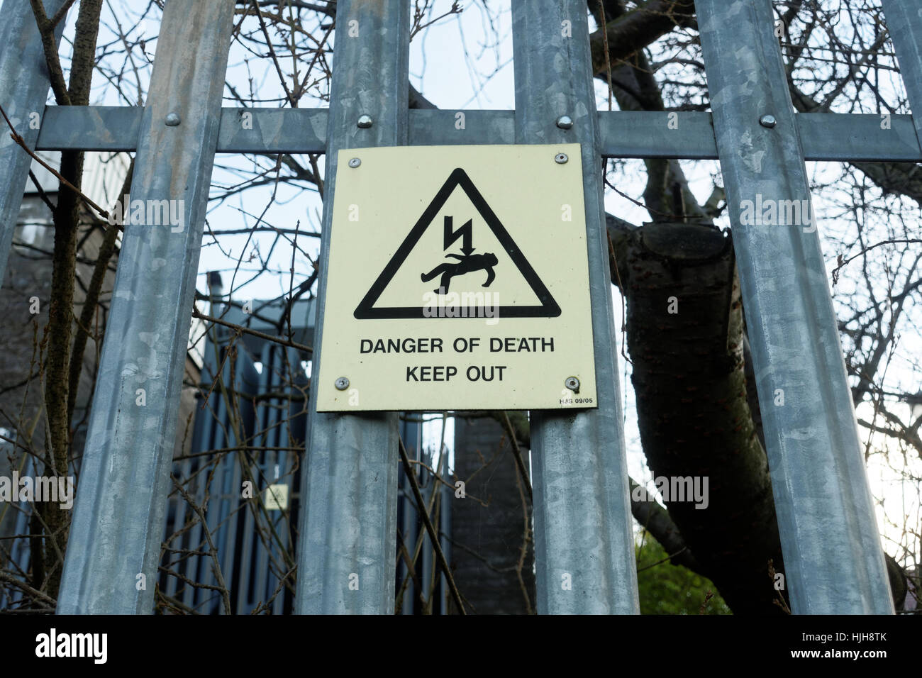 danger of death keep out electricity sign and fence Stock Photo