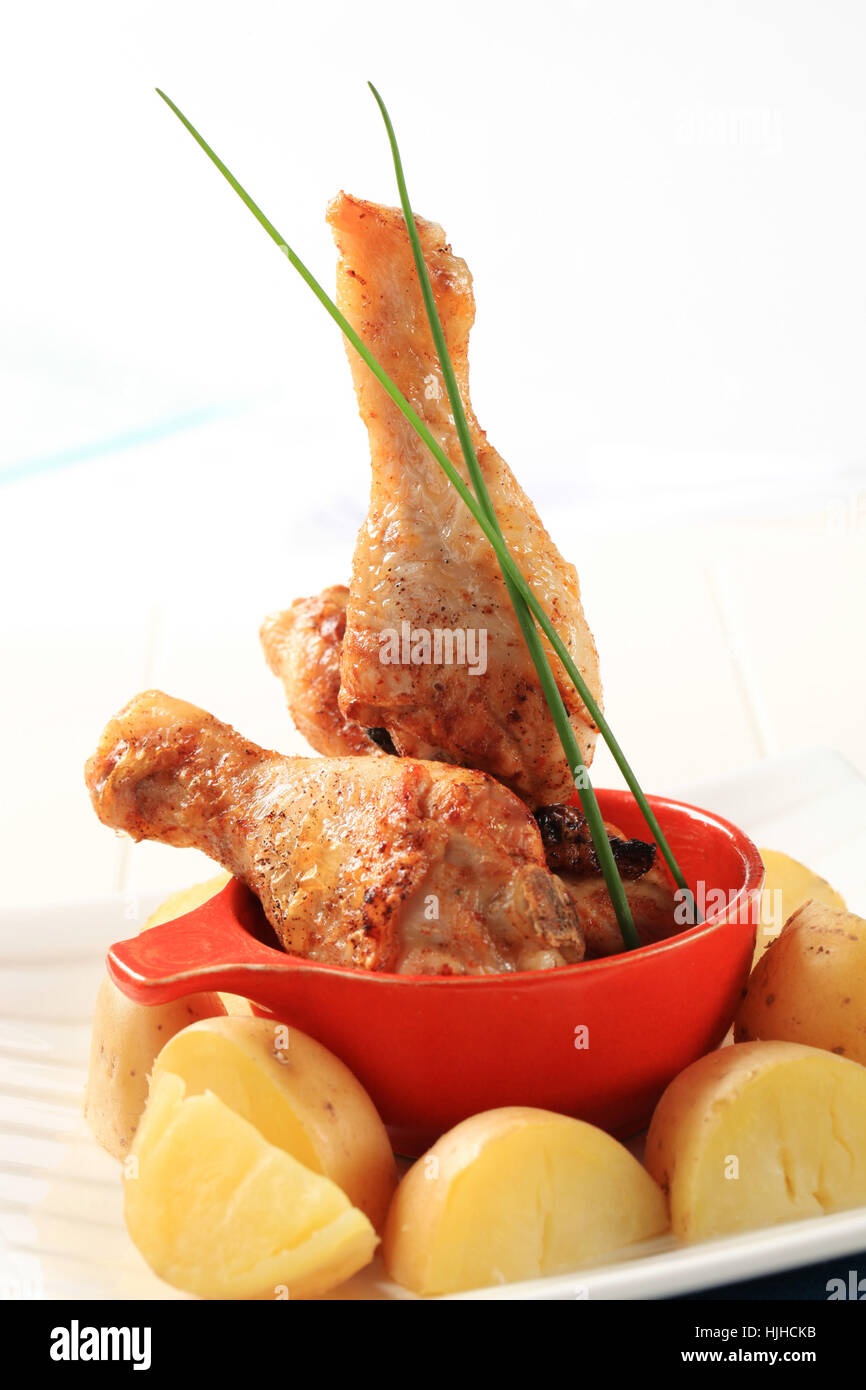 Roasted chicken drumsticks and new potatoes Stock Photo Alamy