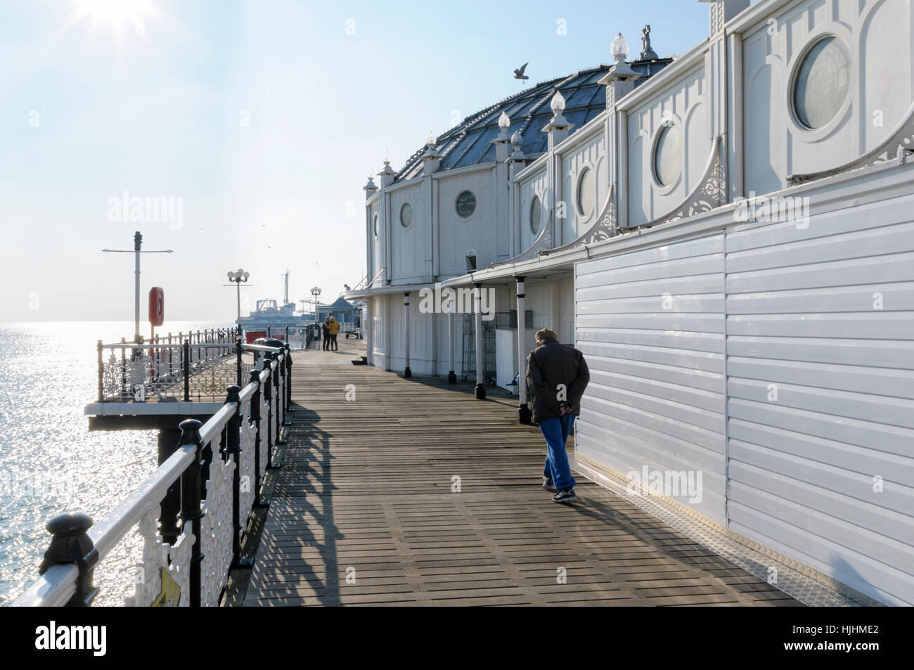An elderly man walks along the Victorian Palace pier, Brighton, Sussex, England, UK Stock Photo