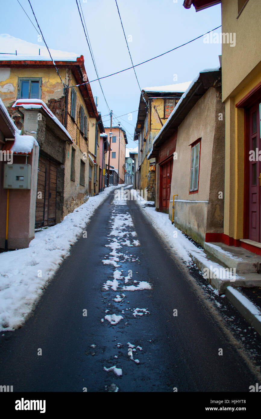 Road in between buildings in A Snowy day Stock Photo