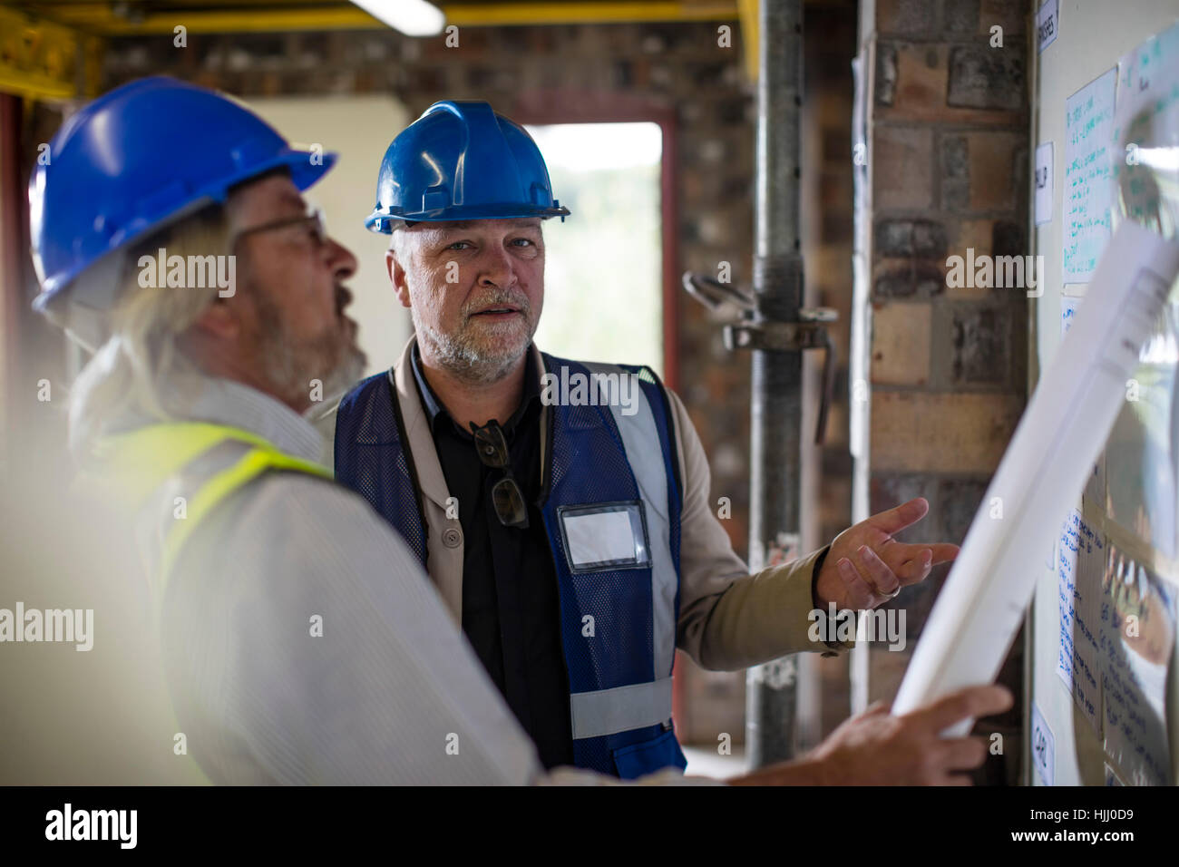 Construction worker and engineer discussing project in site office Stock Photo Alamy