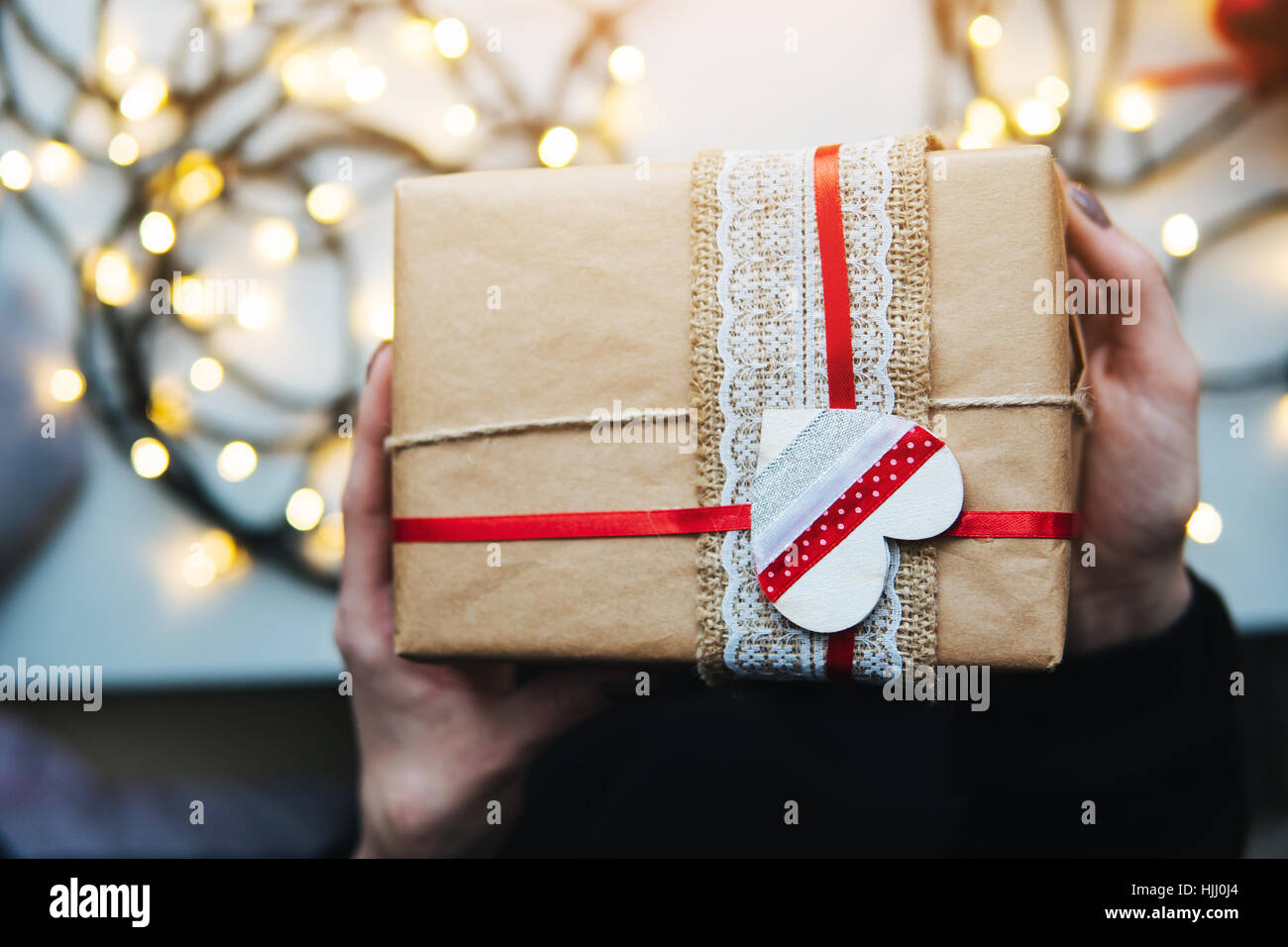 girl holding a Christmas gift in hand Stock Photo - Alamy