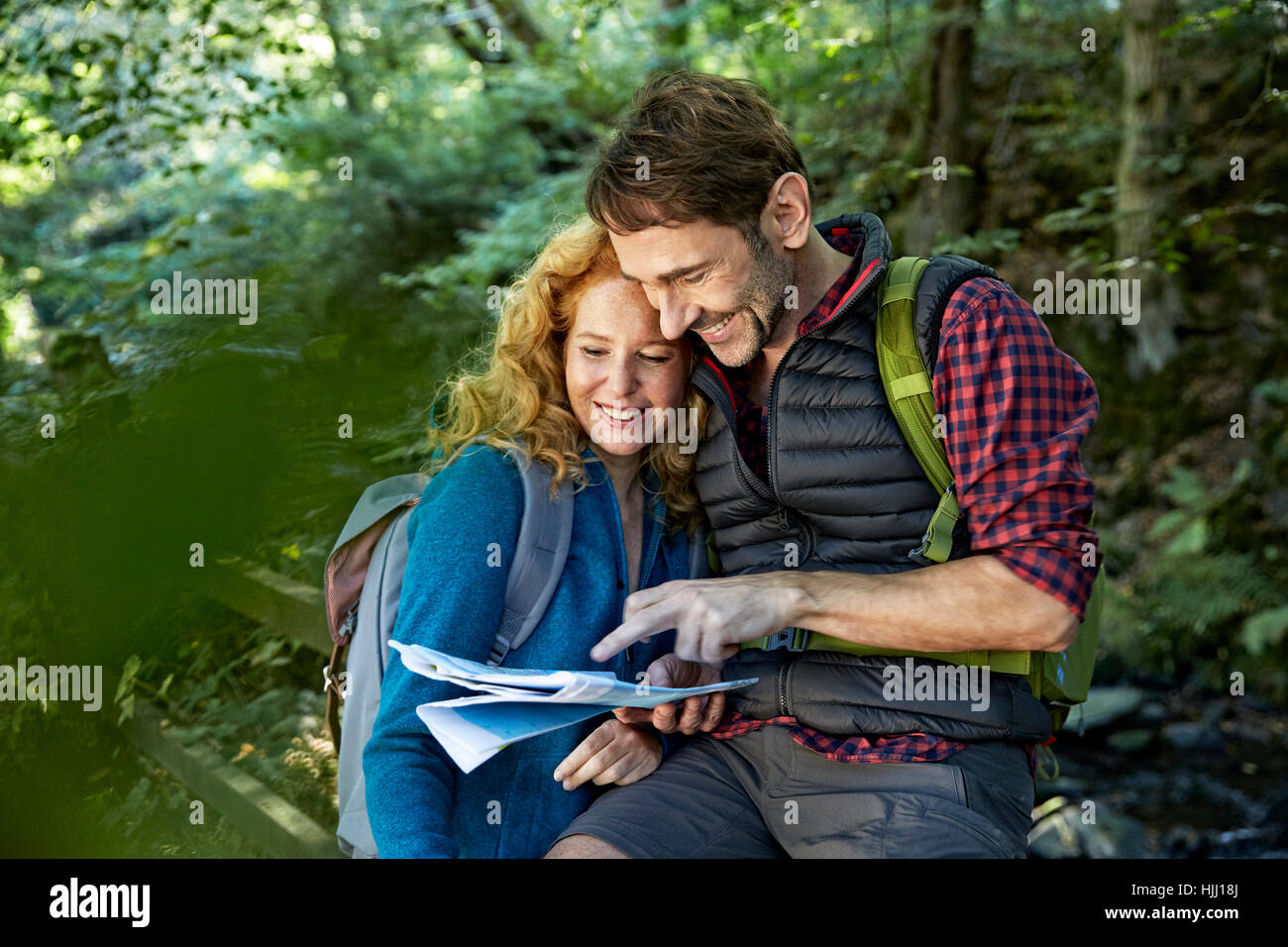 Hiking couple holding map Stock Photo - Alamy