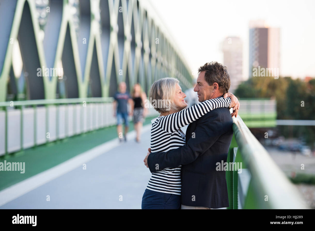 Senior couple embracing on a bridge Stock Photo - Alamy