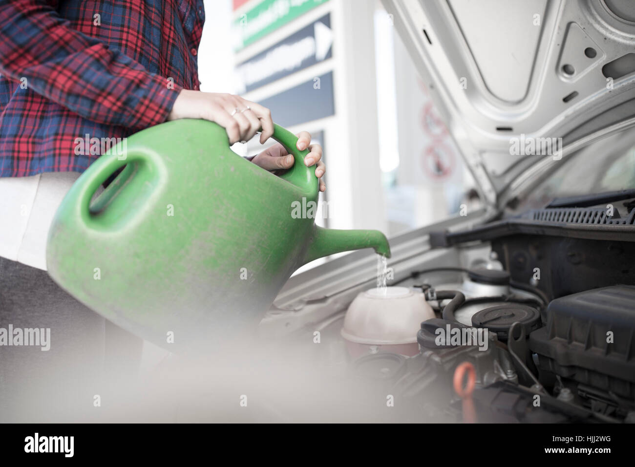 Woman filling up car with water canister Stock Photo Alamy