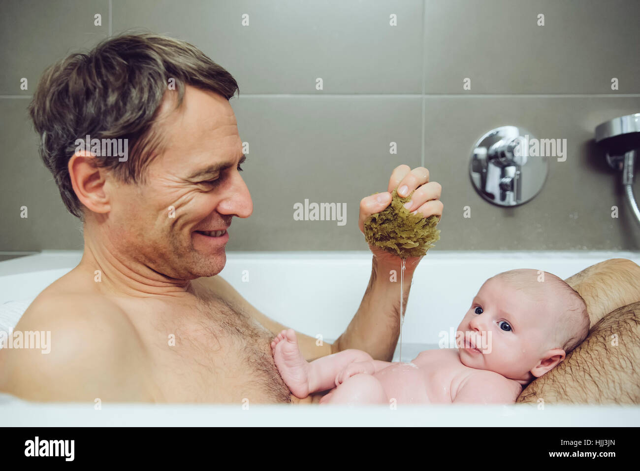 Father and baby taking a bath with a natural sponge Stock Photo Alamy