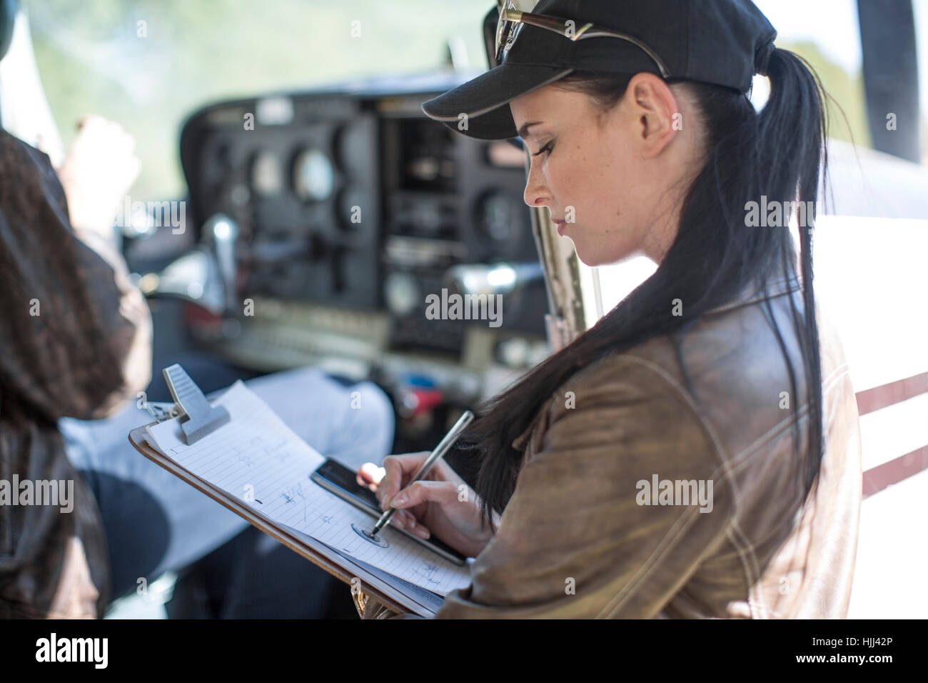 Female pilot inspecting light aircraft cockpit Stock Photo