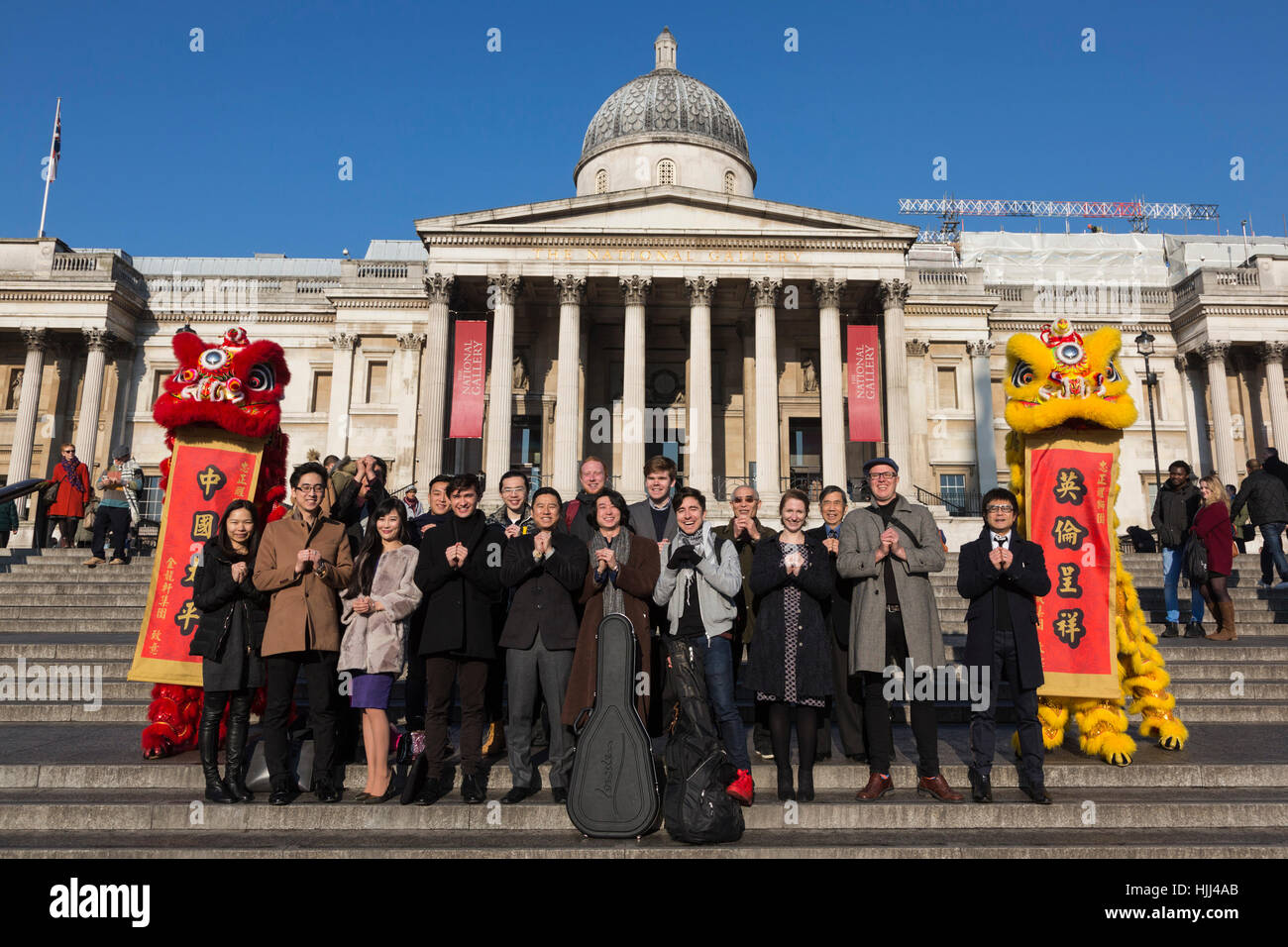 Performers pose with Lion Dancers from Chinatown on the steps of Trafalgar Square in front of the National Gallery ahead of this weekend's 'Year of the Rooster' Chinese New Year celebrations in London, UK. Stock Photo