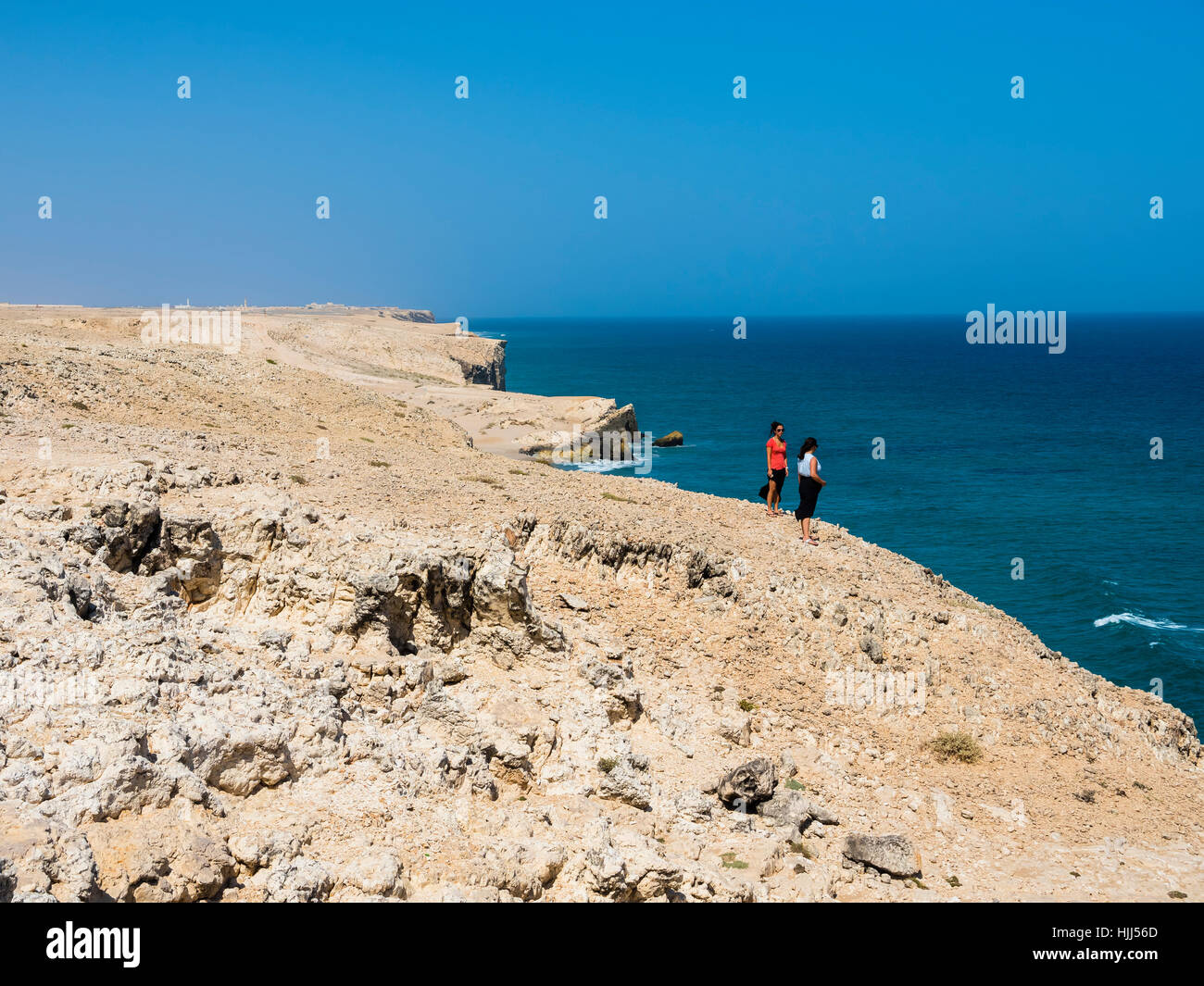 Oman, Ash Sharqiyah, Ad Daffah, two women standing at cliff coast Stock Photo