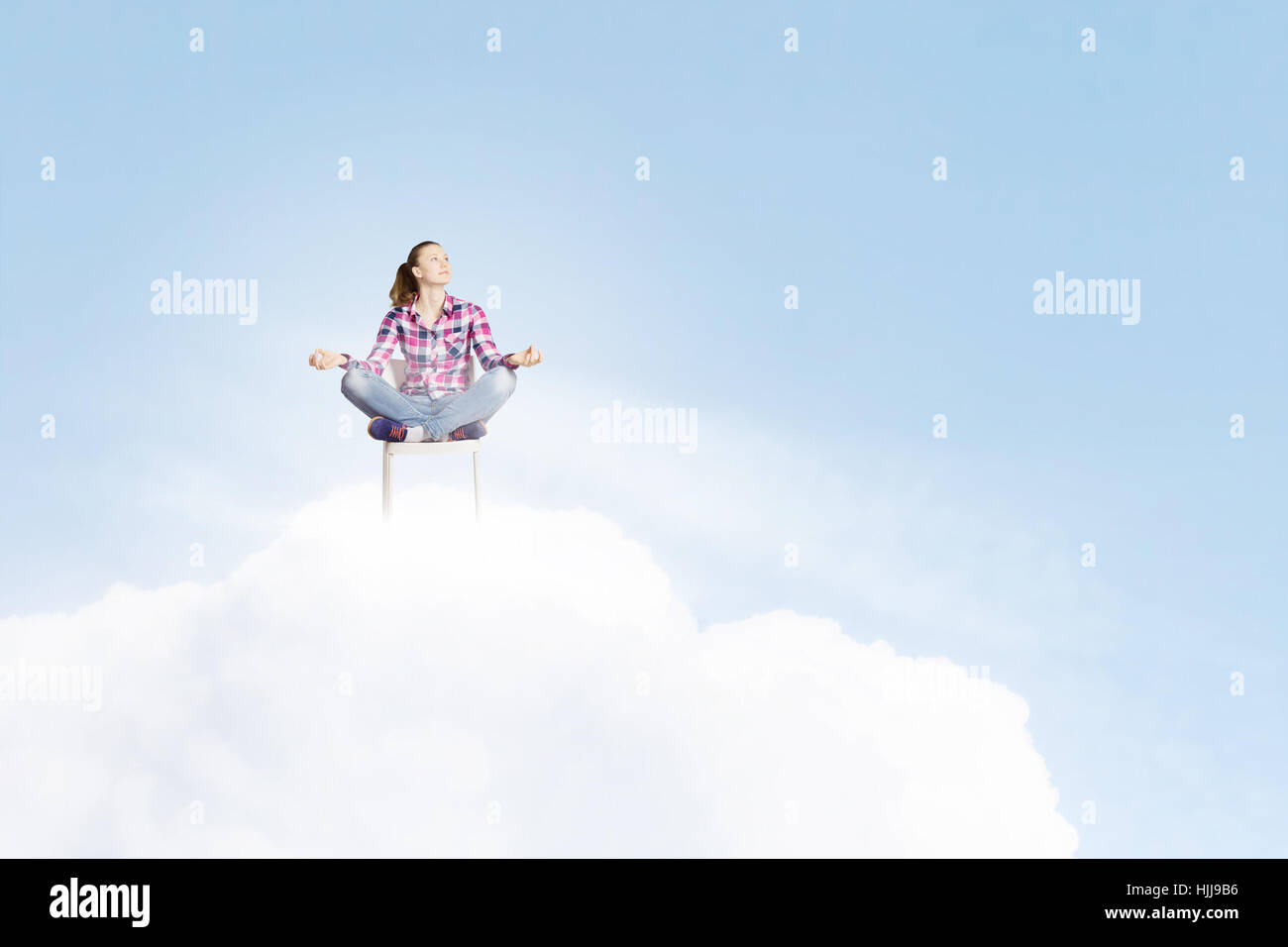 Young woman sitting on chair and meditating Stock Photo - Alamy