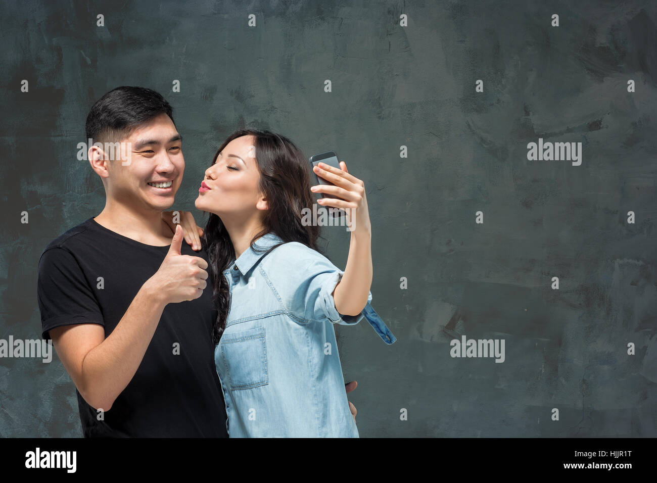 Portrait of smiling Korean couple on a gray Stock Photo