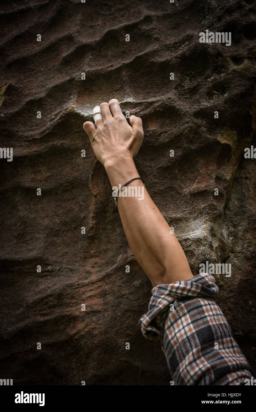 A woman's hand grabbing a hold while rock climbing, bouldering Stock Photo
