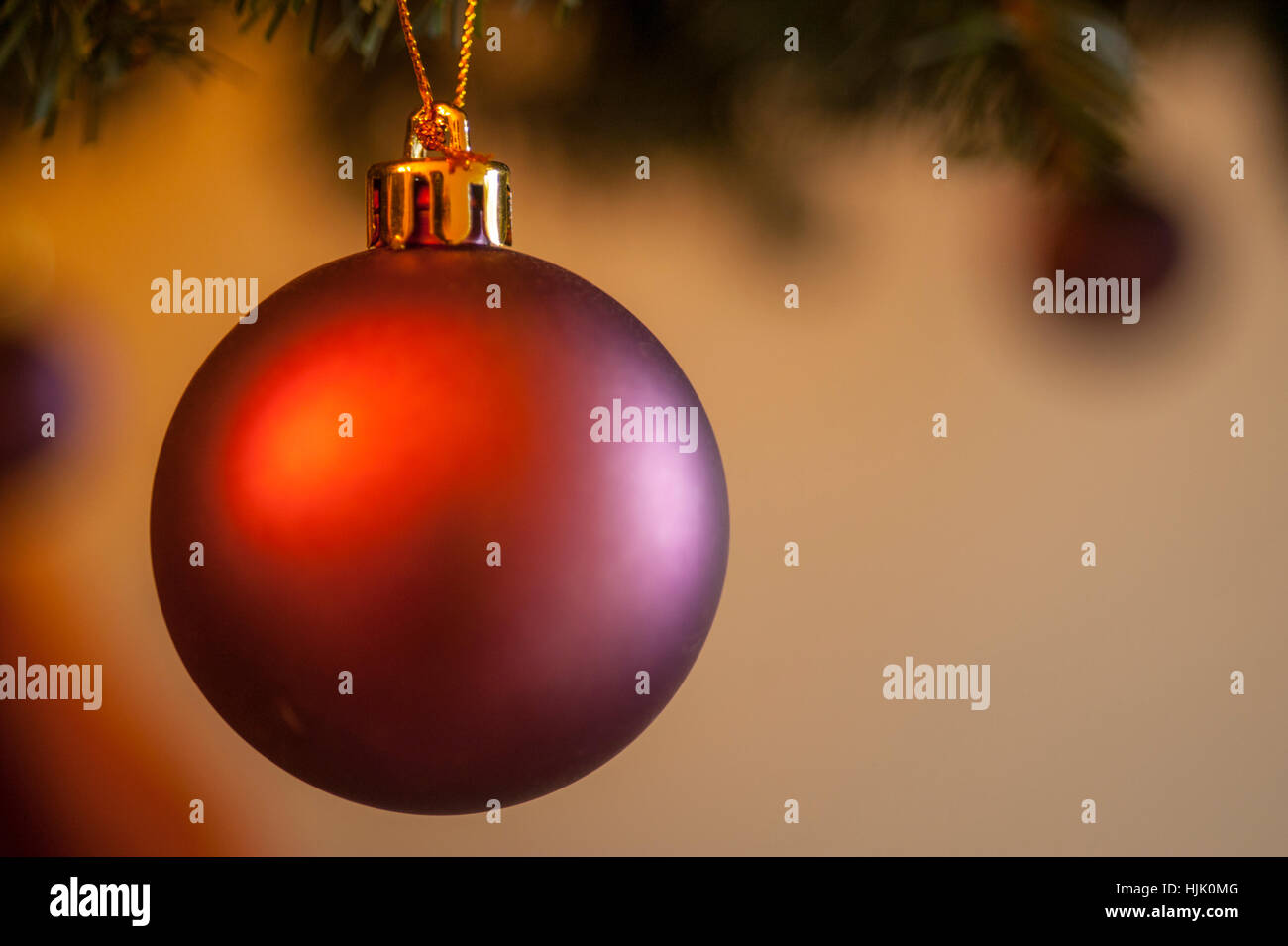 Red Christmas bauble hanging on a christmas tree. Stock Photo