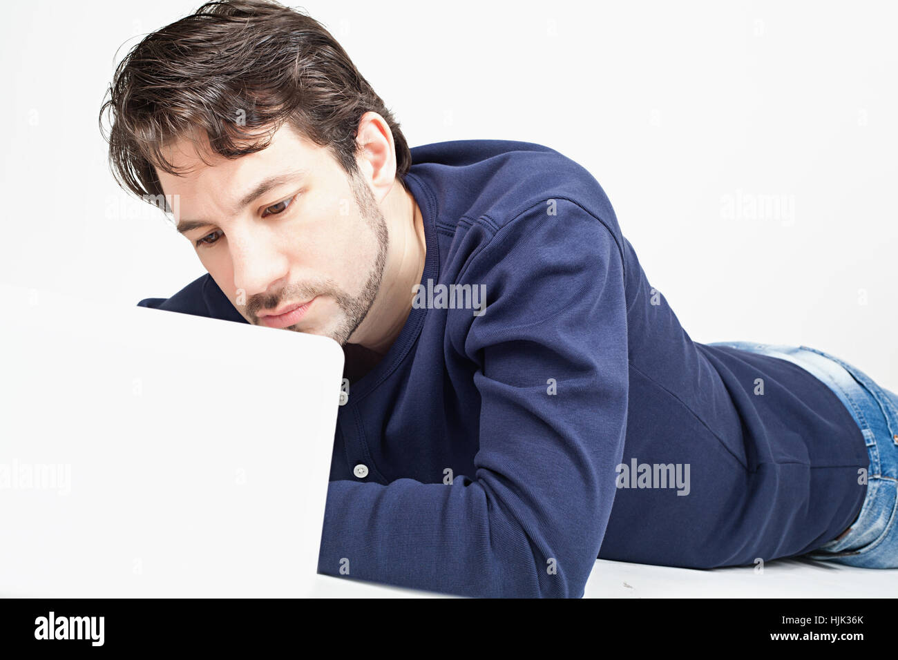young man working on laptop while laying on the floor Stock Photo