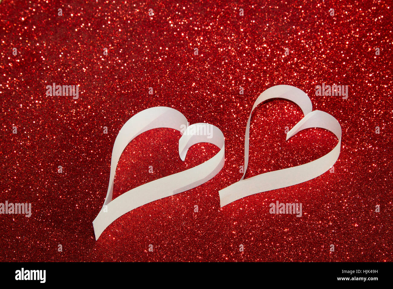 Two white hearts from paper on red shining background Stock Photo - Alamy