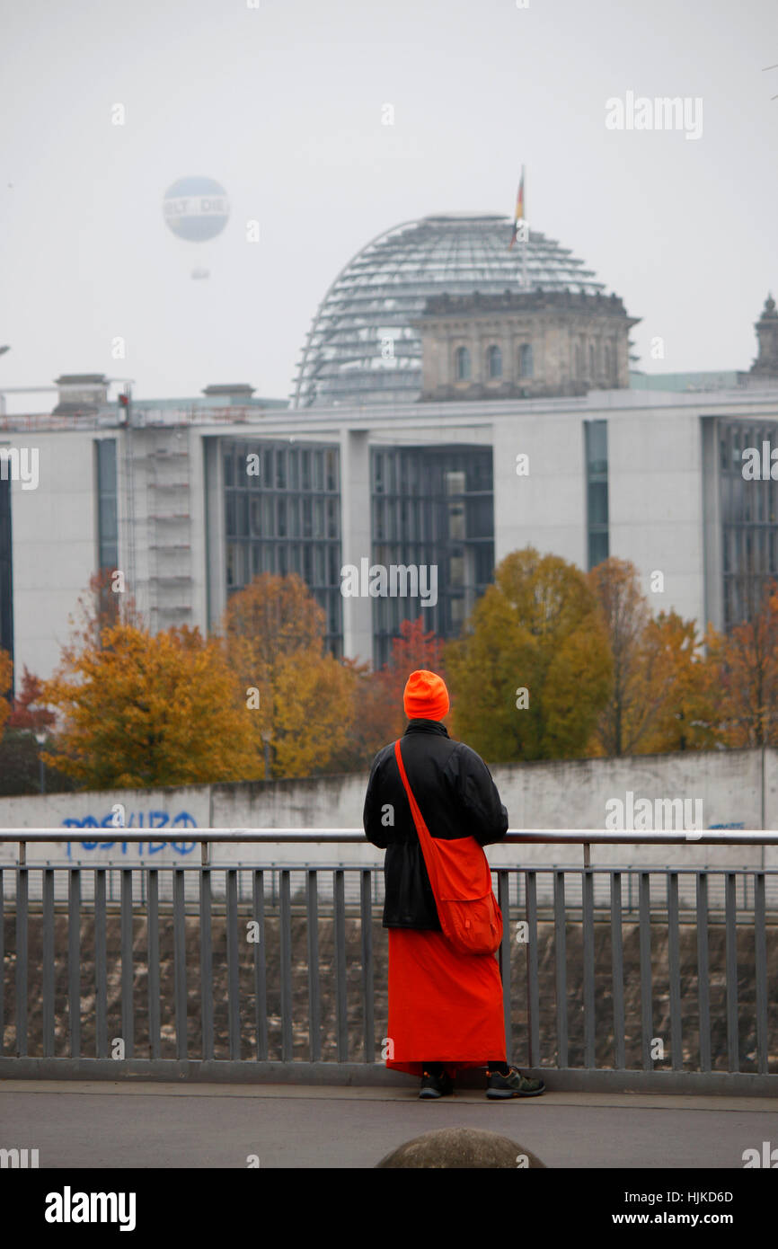 Hare Krishna Juenger betrachtet die Skyline von Berlins Regierungsviertel mit der Kuppel des Reichstagsgebaeudes, Berlin-Tiergarten. Stock Photo