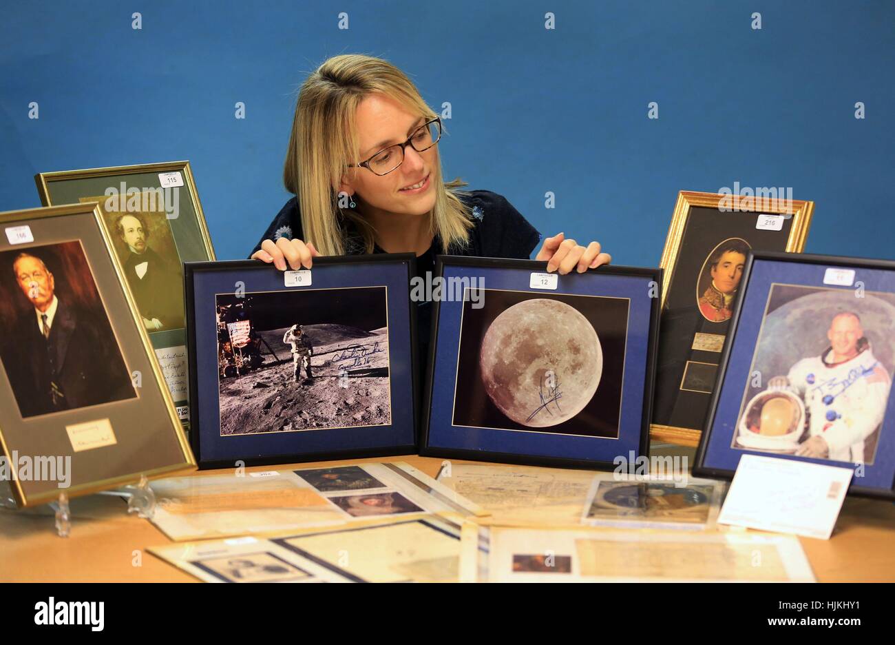 Laura Sykes holds pictures with the signatures of Buzz Aldrin (left) and Neil Armstrong (right) which were some of more than 1,000 signatures of famous historical figures from the past five centuries, collected by John Evans before his death aged 90 in 2007, auctioned by Campbells Auctioneers in Worthing, West Sussex. Stock Photo
