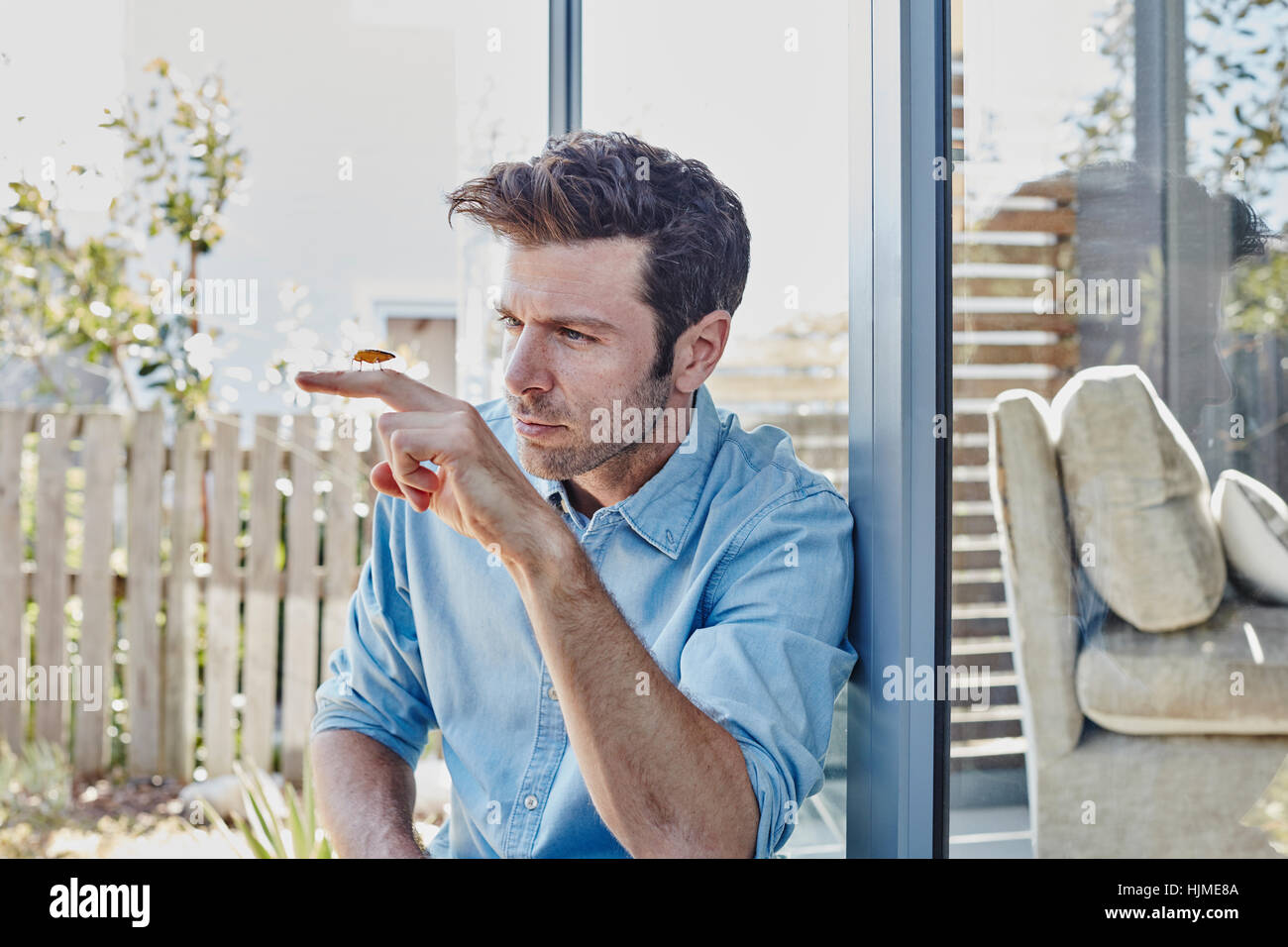 man at home watching cricket on his finger Stock Photo