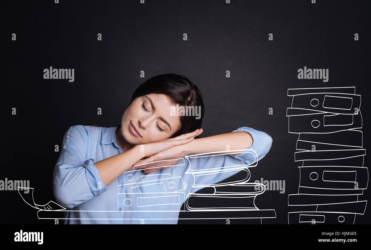 Pleasant tired woman sleeping on the books Stock Photo - Alamy