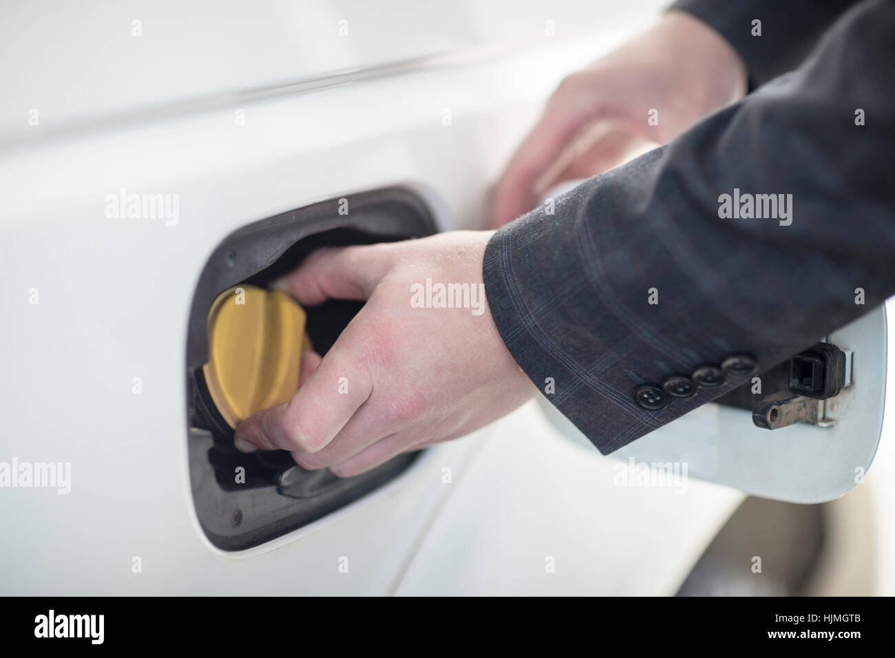 Man closing petrol cap of car at fuel station Stock Photo