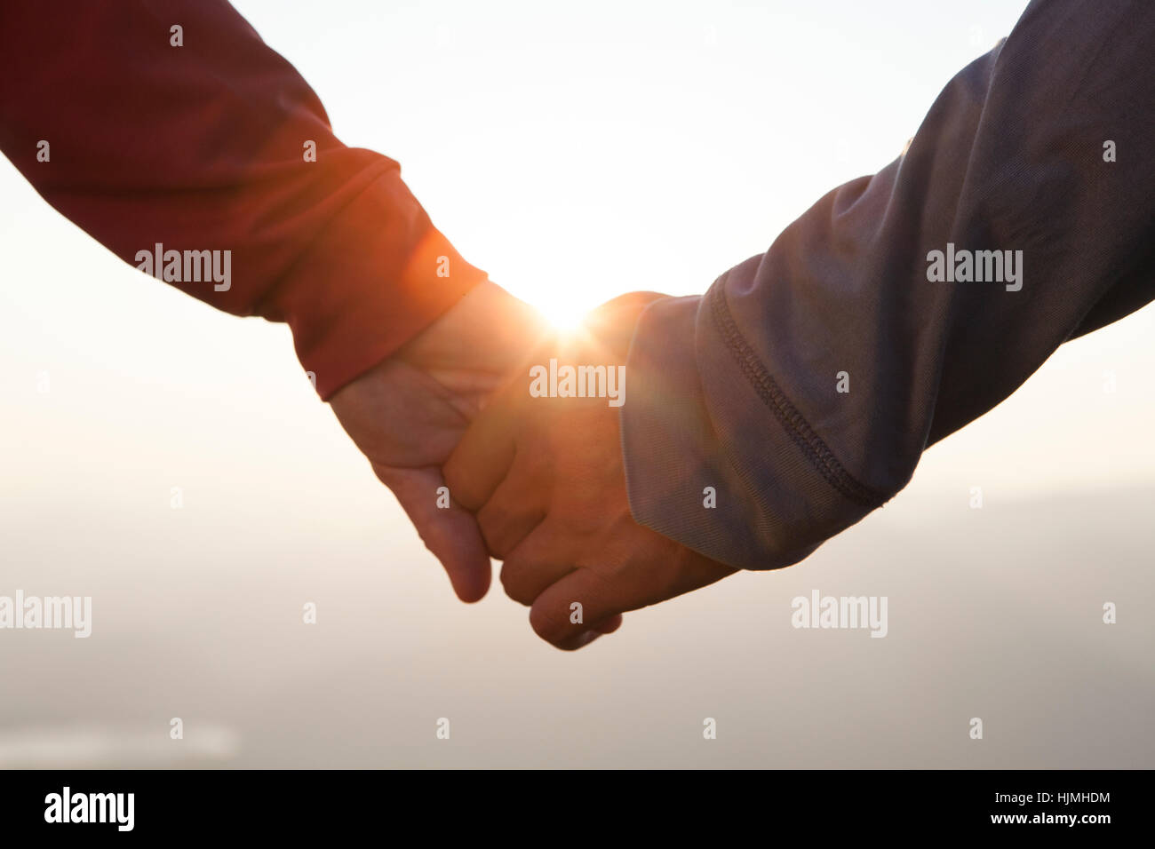 Couple hand in hand at sunset Stock Photo