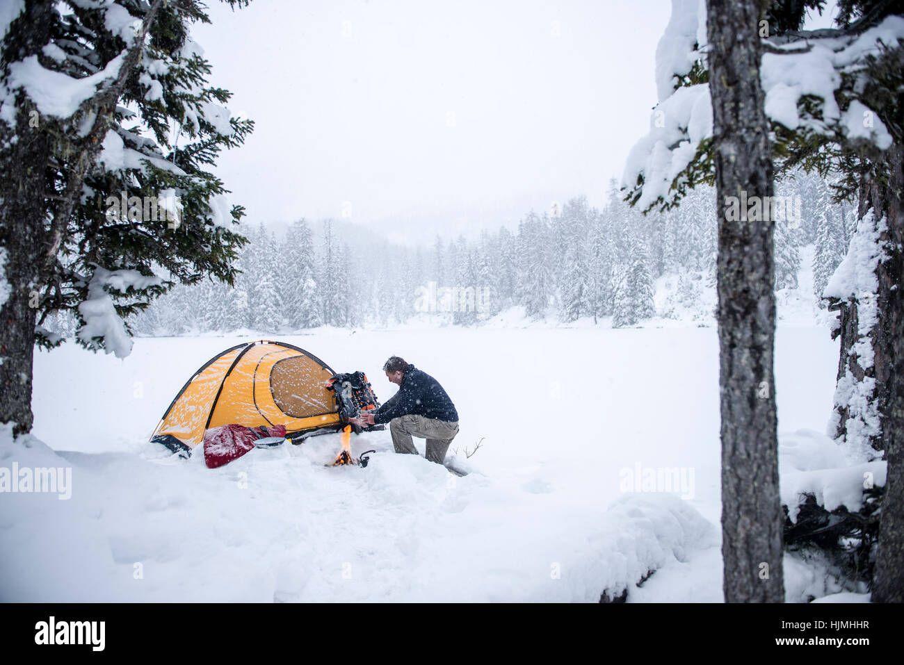 Senior man camping in snow-covered landscape Stock Photo