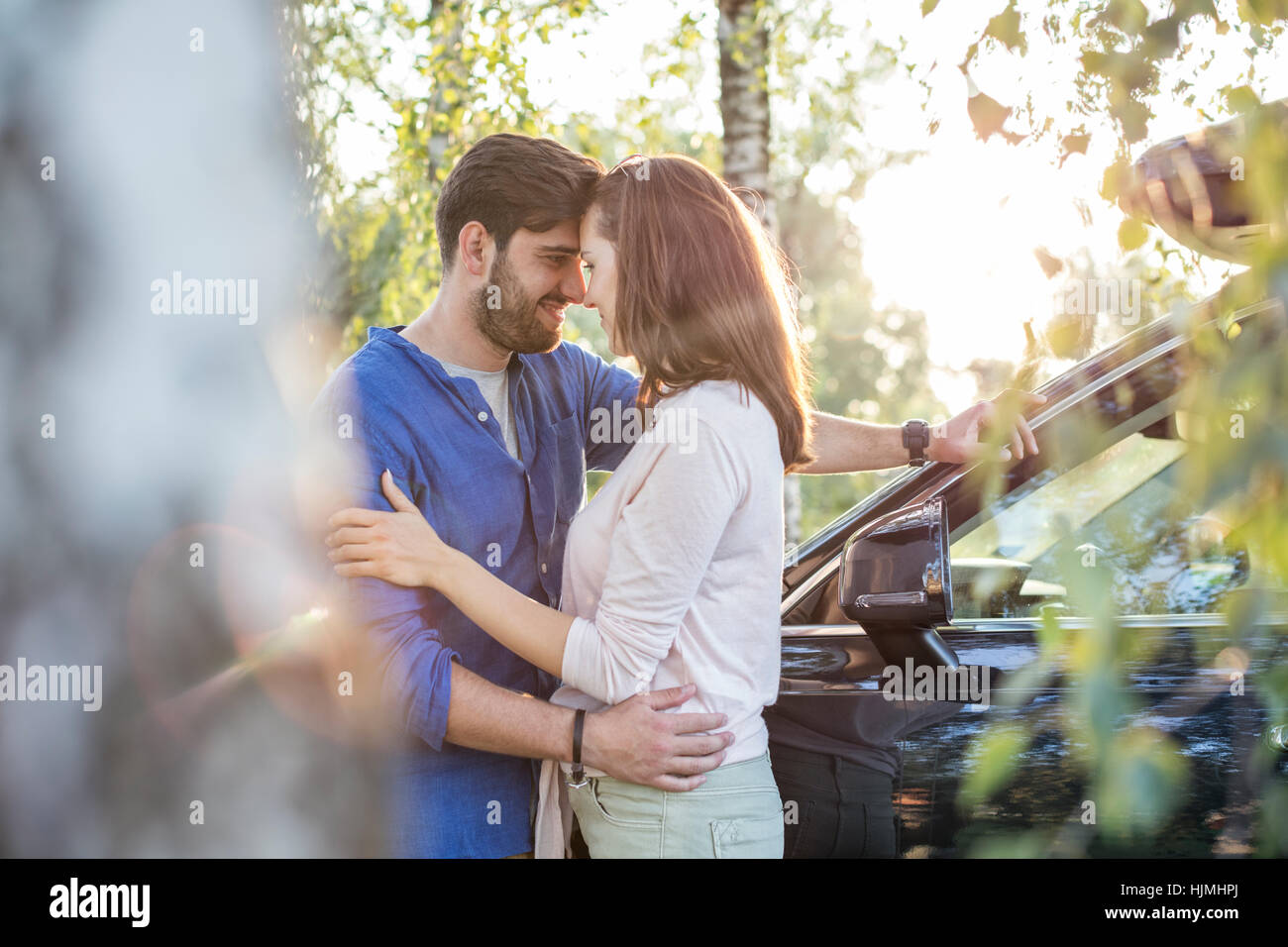 Couple embracing and kissing while on a road trip Stock Photo - Alamy