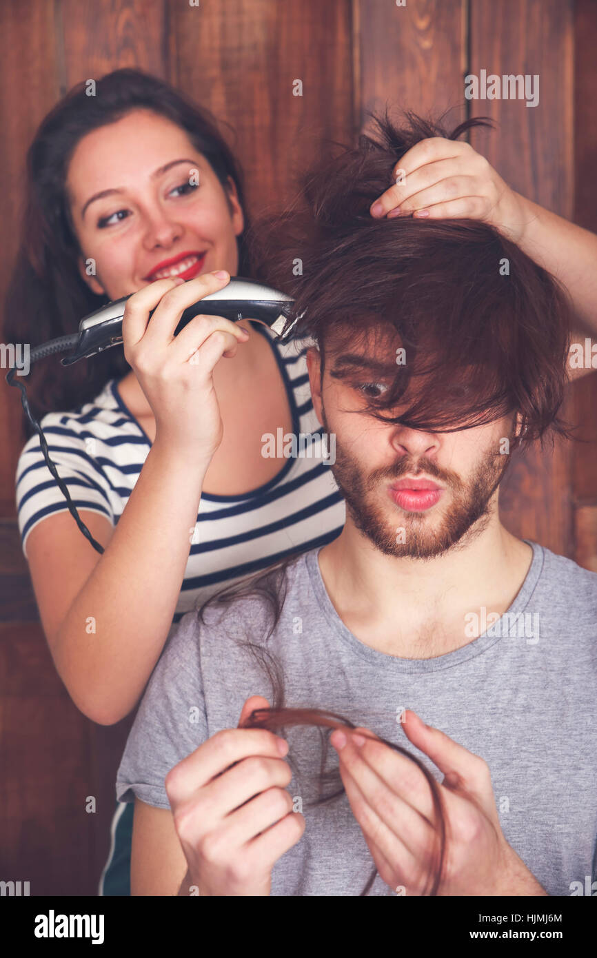 Young Man Getting A Haircut By His Girlfriend With Hair Cutting