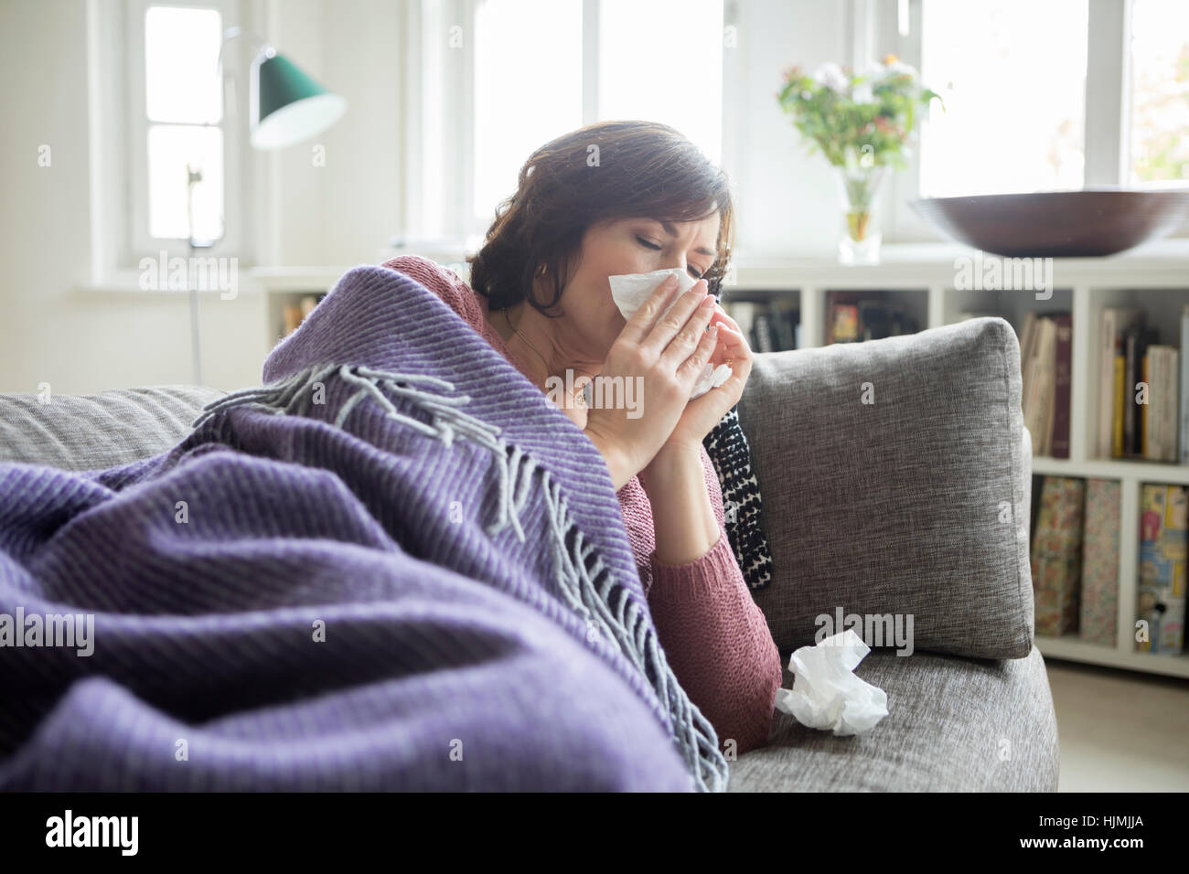 Woman having a cold lying on the sofa Stock Photo Alamy