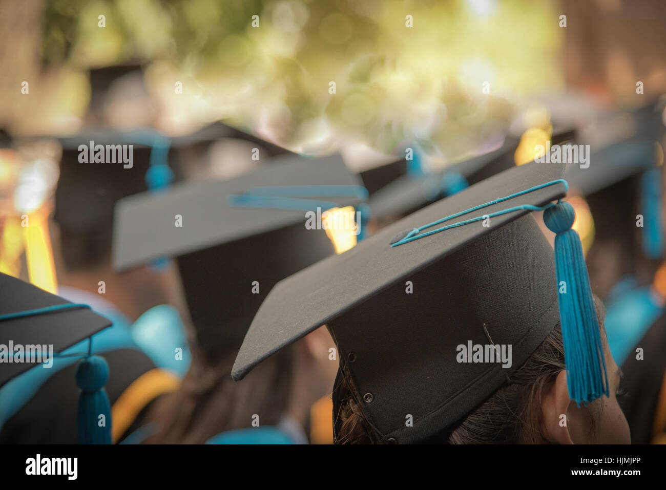 Selective Focus On Graduation Cap Of Front Female In Graduation Ceremony Row Stock Photo