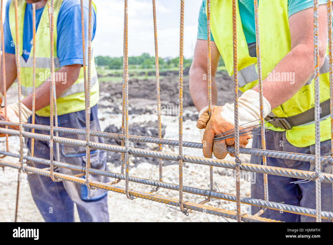 Worker is tying rebar to make a newly constructed footing frame. Binding concrete frame Stock