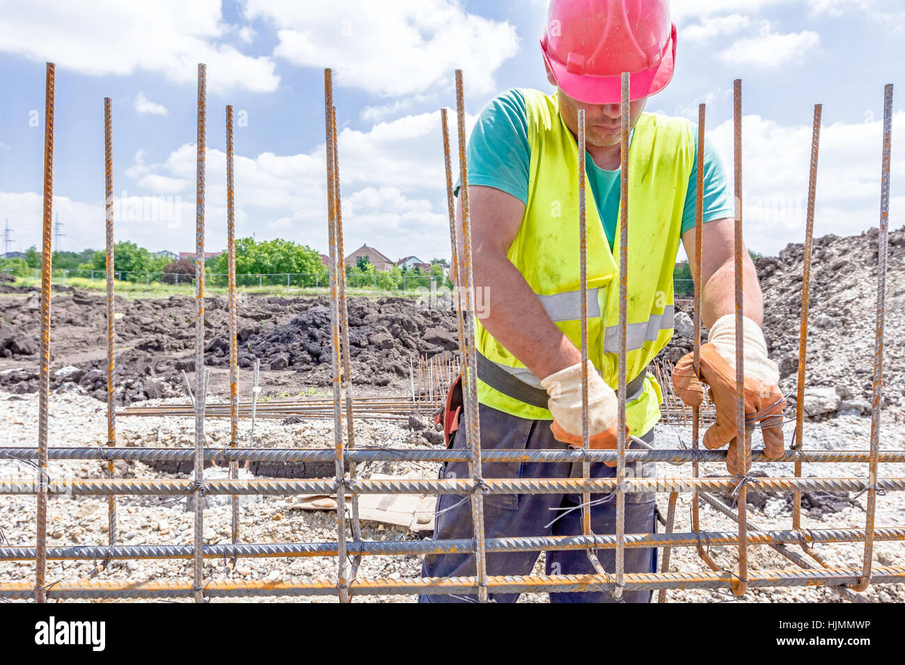 Zrenjanin, Vojvodina, Serbia - May 29, 2015: Worker is tying rebar to make a newly constructed footing frame. Binding concrete frame Stock Photo