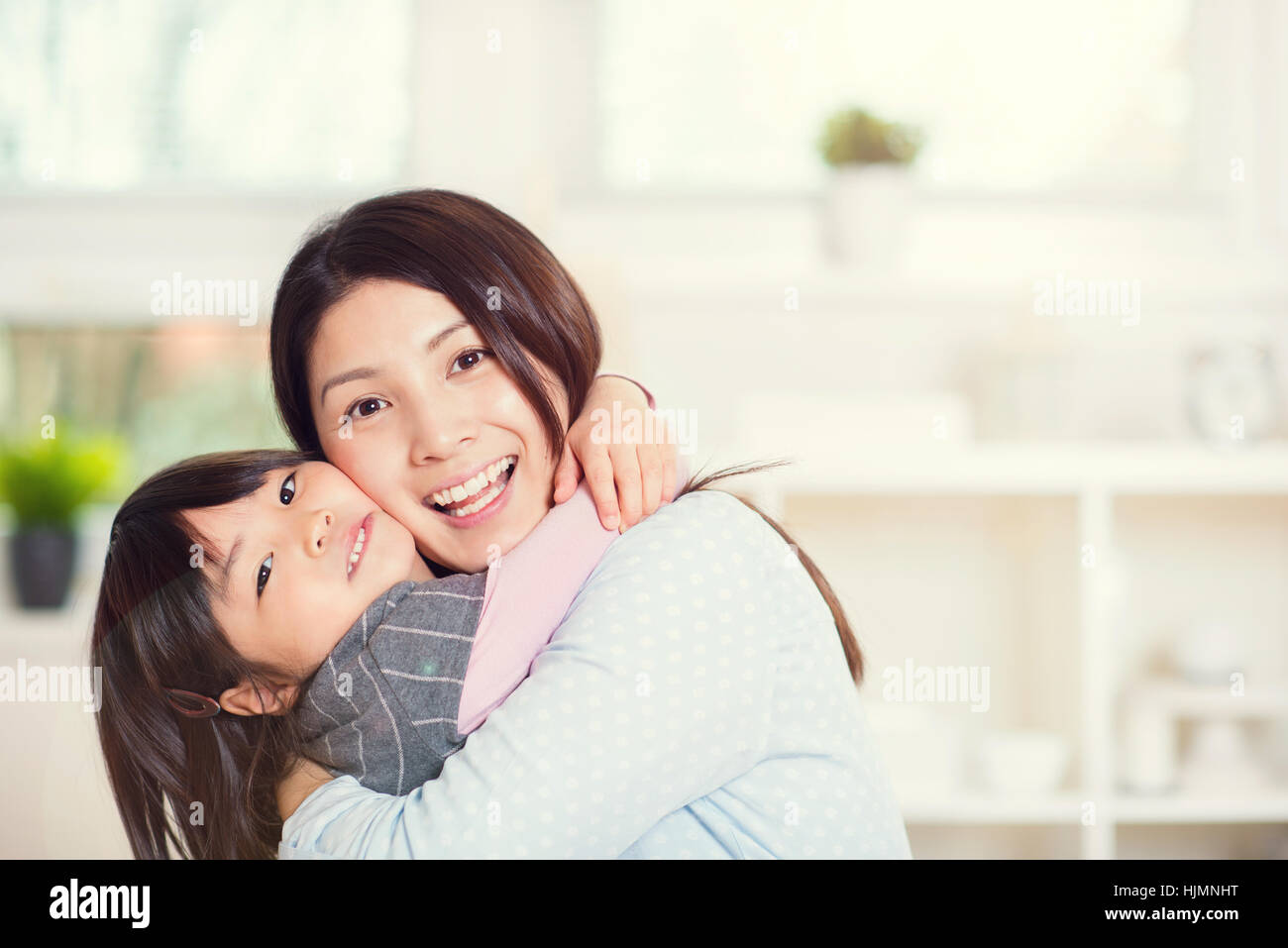 Portrait of happy japanese mother hugging with her cute little daughter