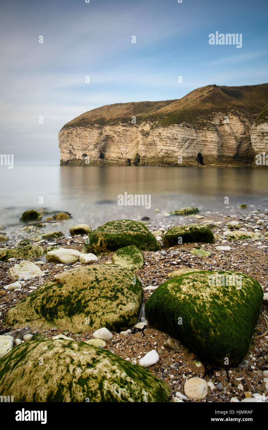 Summer evening view of rocky beach, towering chalk cliffs & calm sea at North Landing, Flamborough Head, on the east coast of Yorkshire, England, UK. Stock Photo