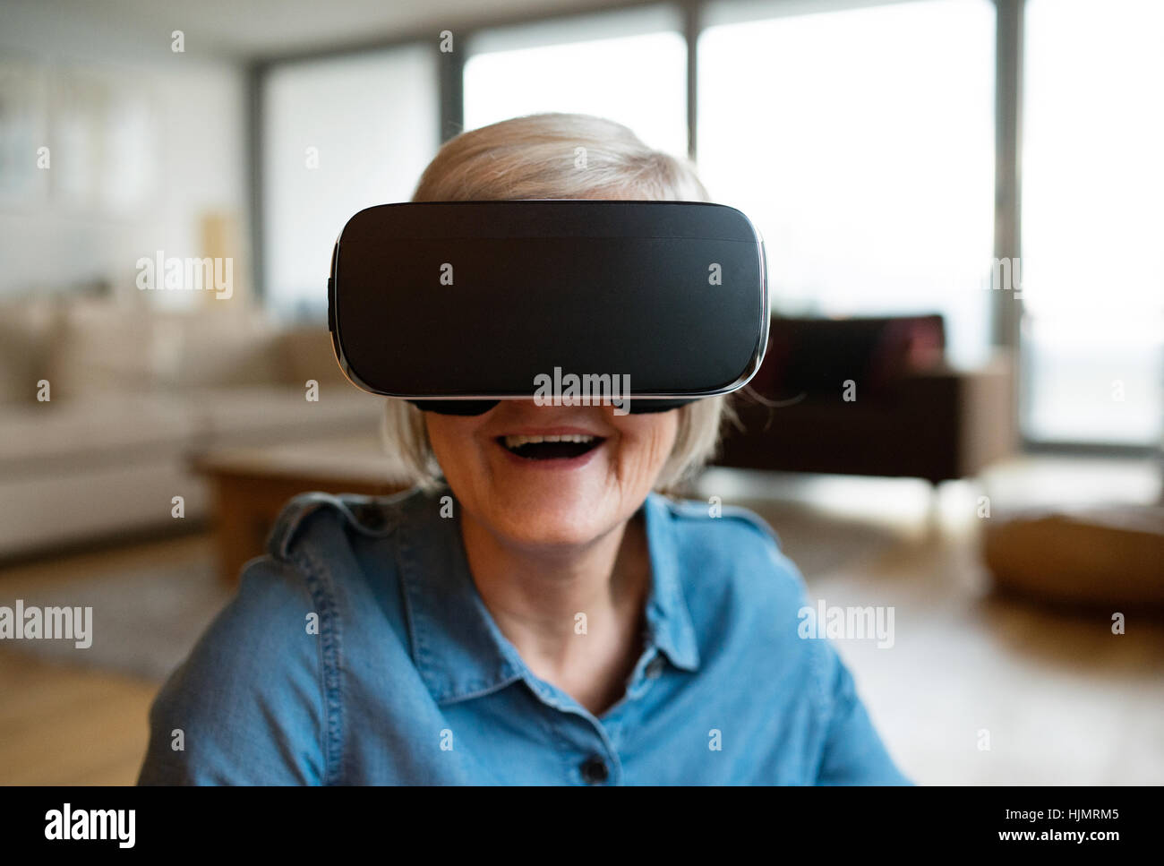Senior woman wearing virtual reality goggles at home Stock Photo - Alamy