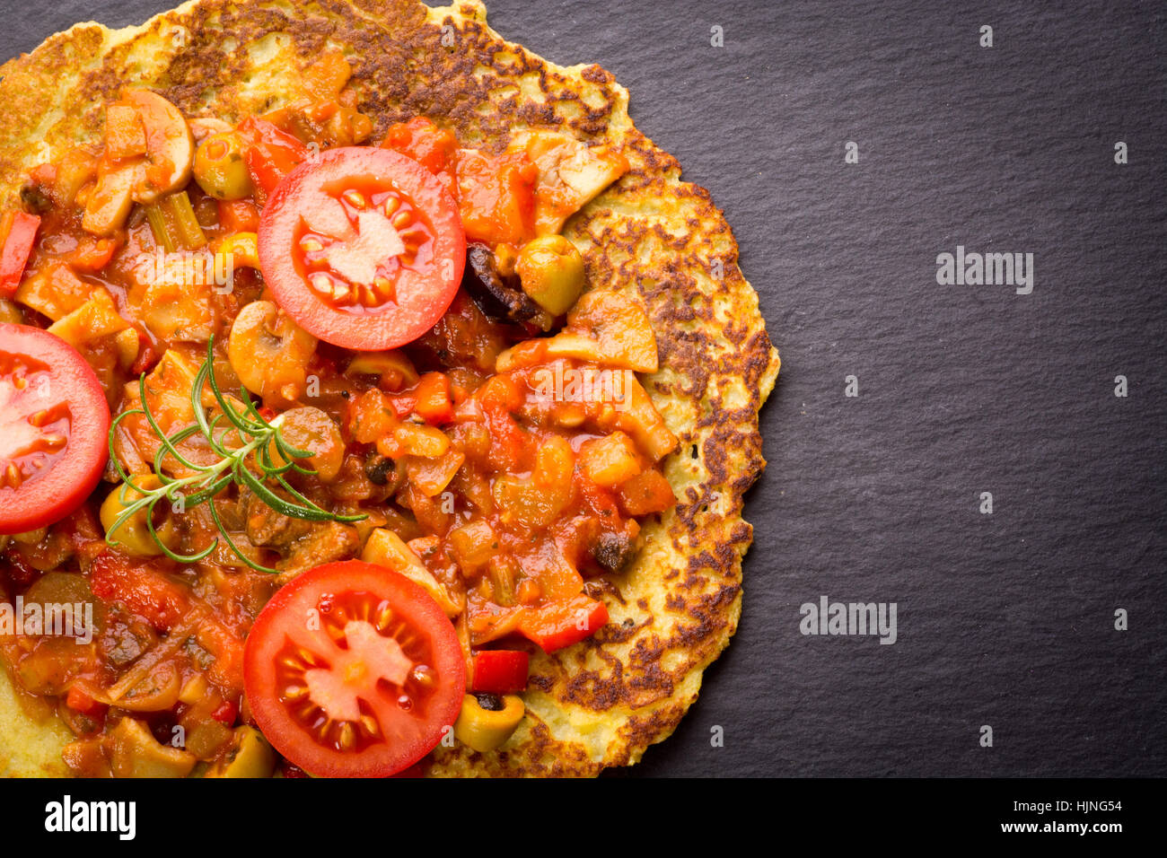 Hungarian style potato pancake with stew and tomatoes Stock Photo
