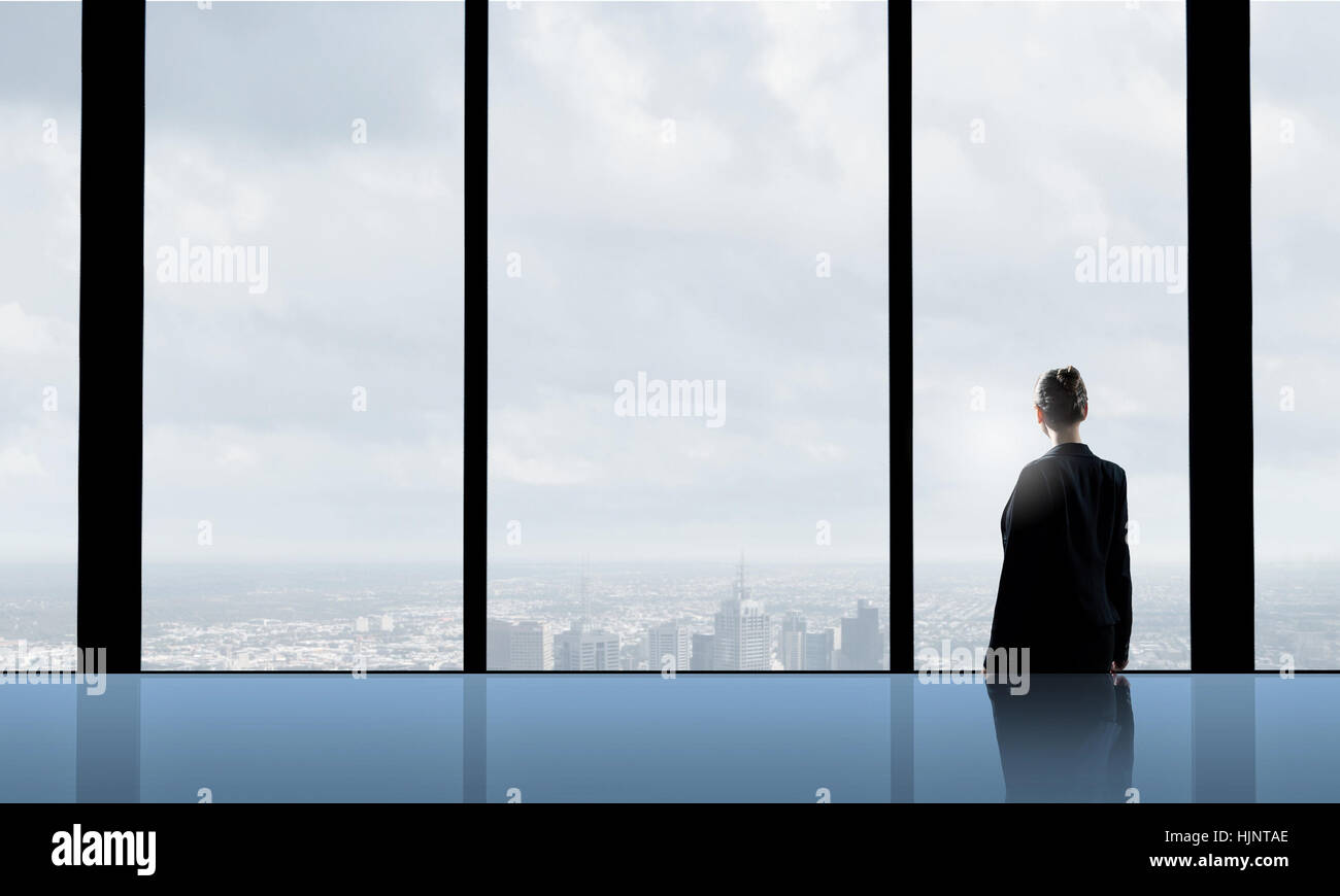 Back view of businesswoman looking in office window Stock Photo - Alamy