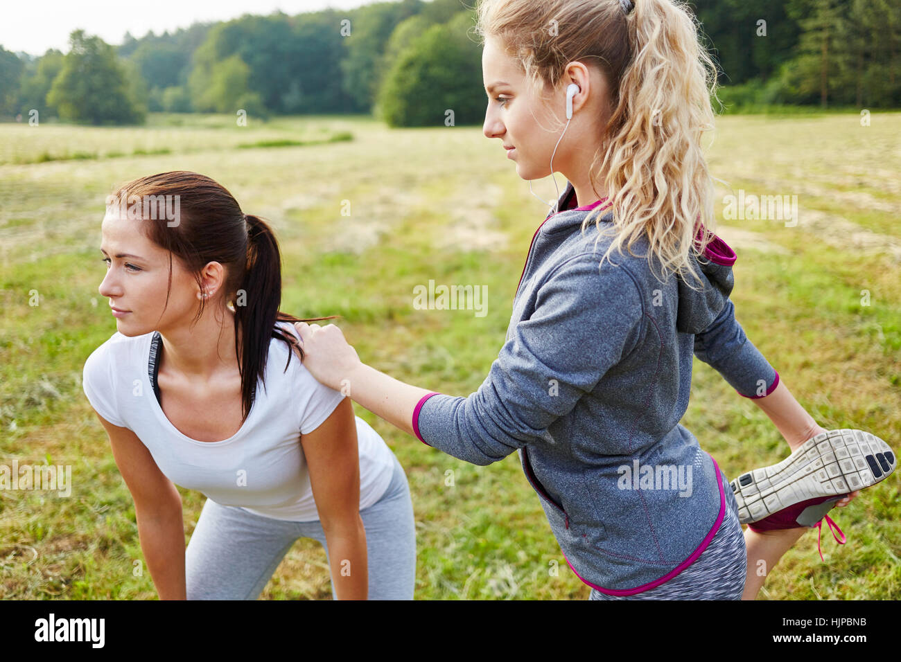 Two women stretching during fitness workout Stock Photo