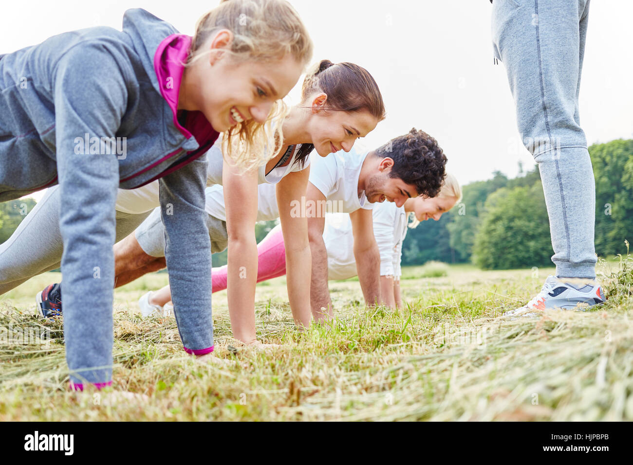 Young people making push ups in training in nature Stock Photo