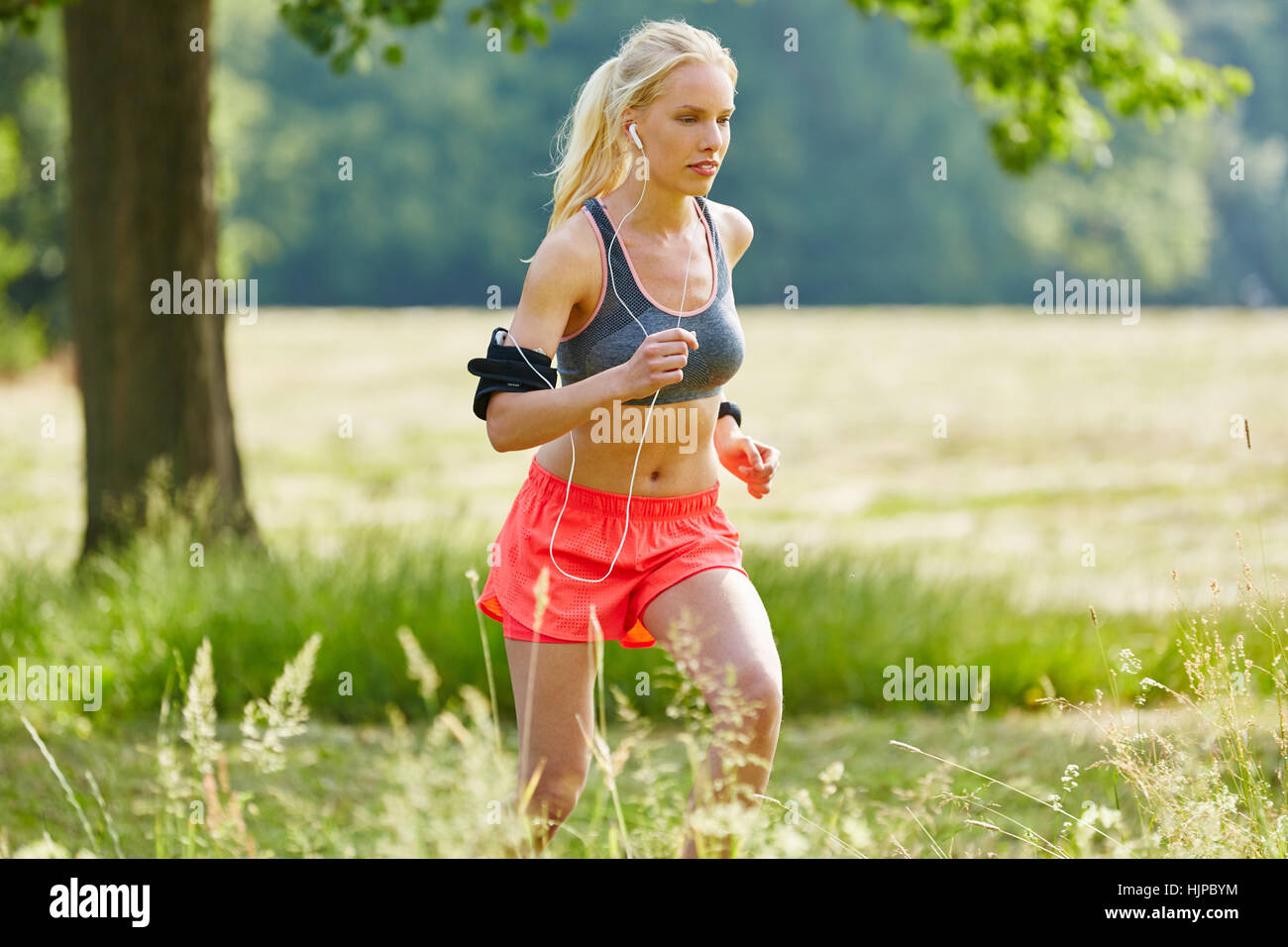 Woman training and jogging while listening to music with mp3 player Stock Photo