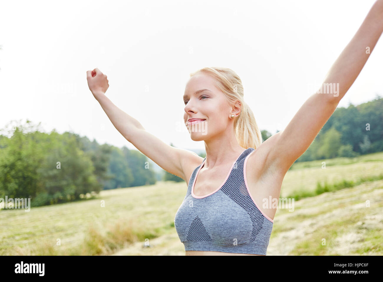Young woman making wellness exercise in the nature in summer Stock Photo