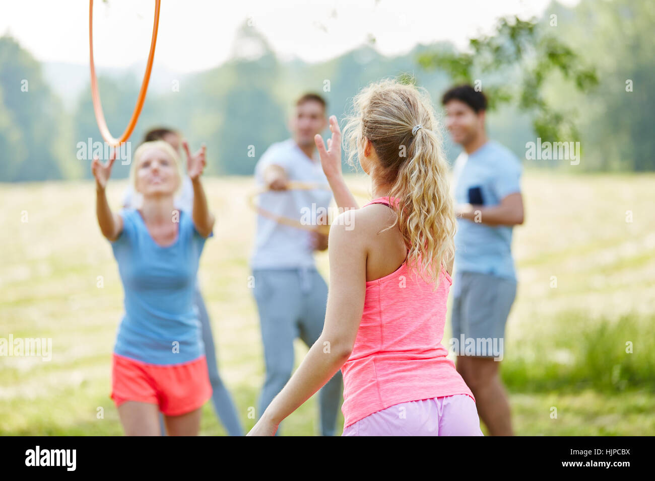Friends play catching hulas in the nature for fitness Stock Photo