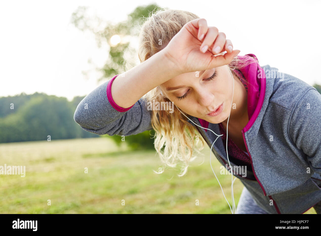Exhausted woman after jogging catching her breath Stock Photo