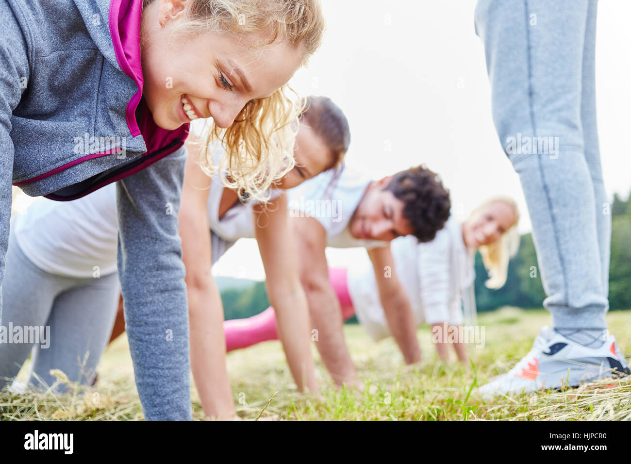 Group of young people training making push ups Stock Photo