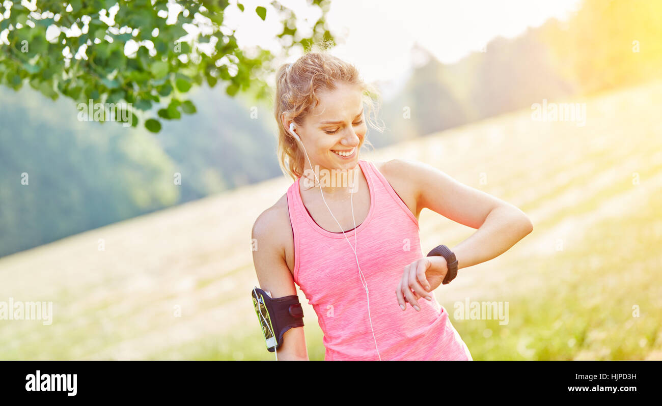 Woman jogging with wearable smartwatch and mp3 player Stock Photo