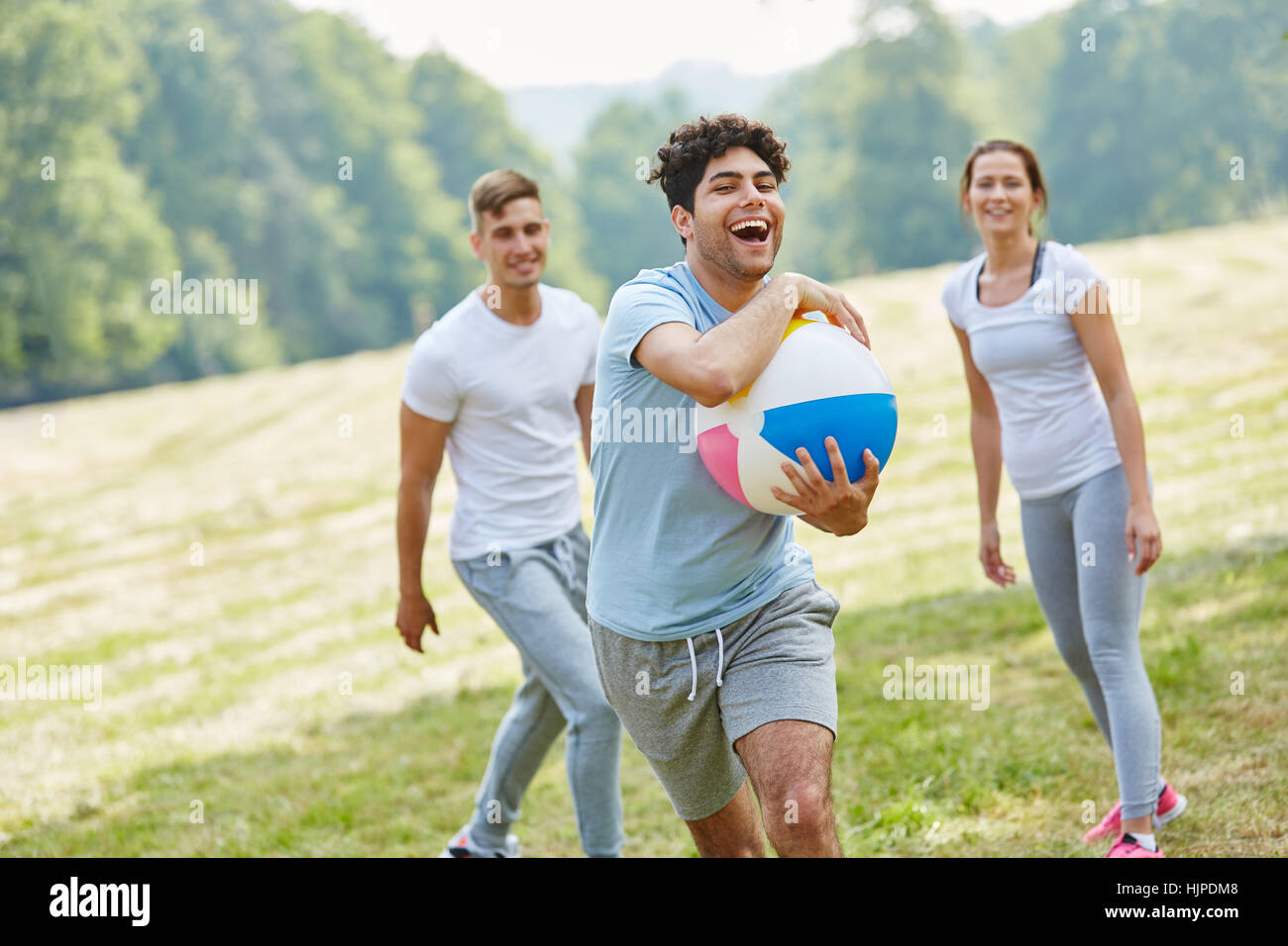 Friends playing with ball together in the park and having fun Stock ...