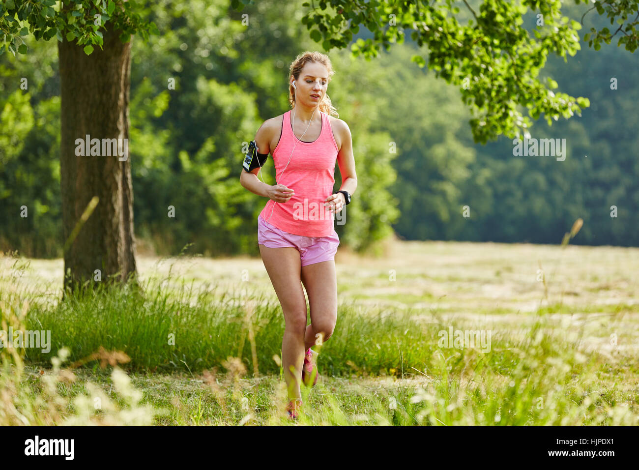 Sporty young woman running during fitness training in the nature Stock Photo