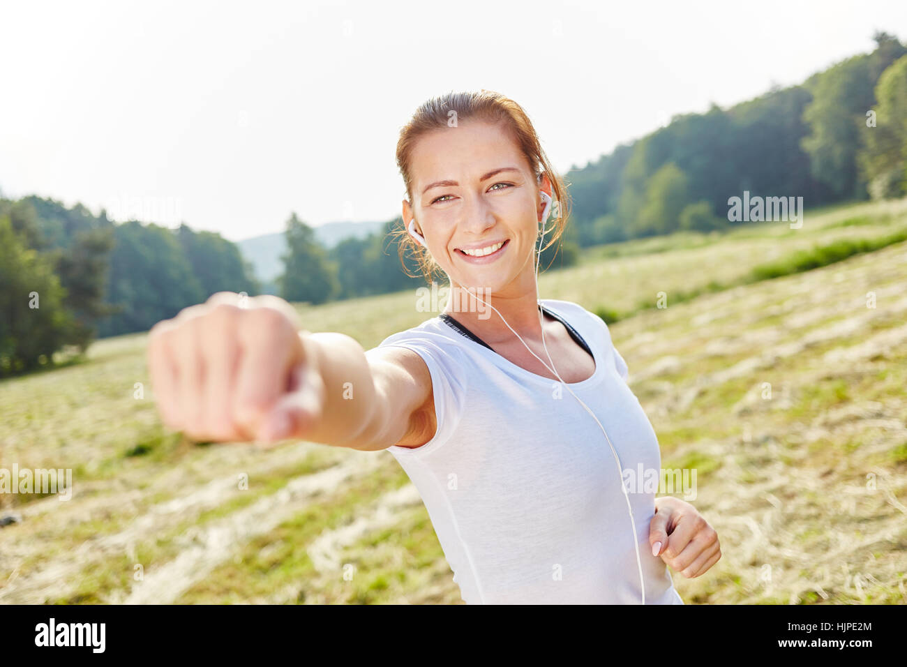 Young woman clenches fist in the air as boxing workout training Stock Photo